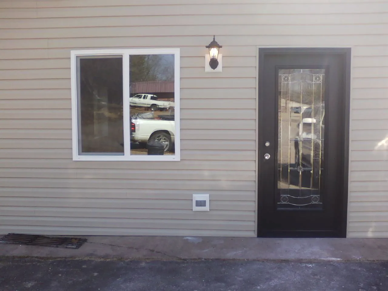 New siding, window and entry door on the side of an addition in Atkins