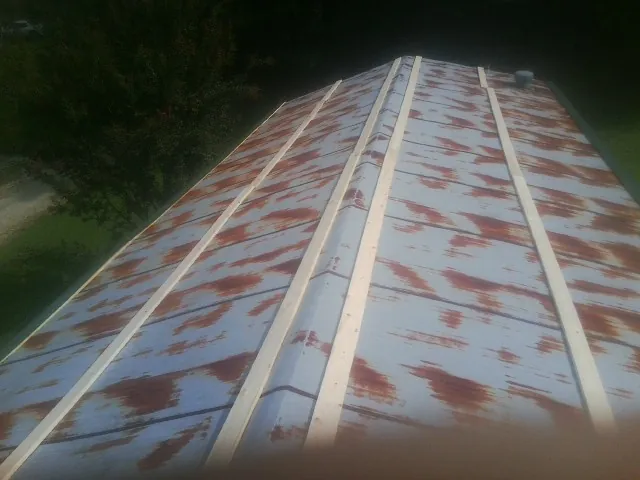 Rusted metal roof panels with new wood purlins before replacement — Storm Damage Roof Repair in Atkins by Roofing Brothers