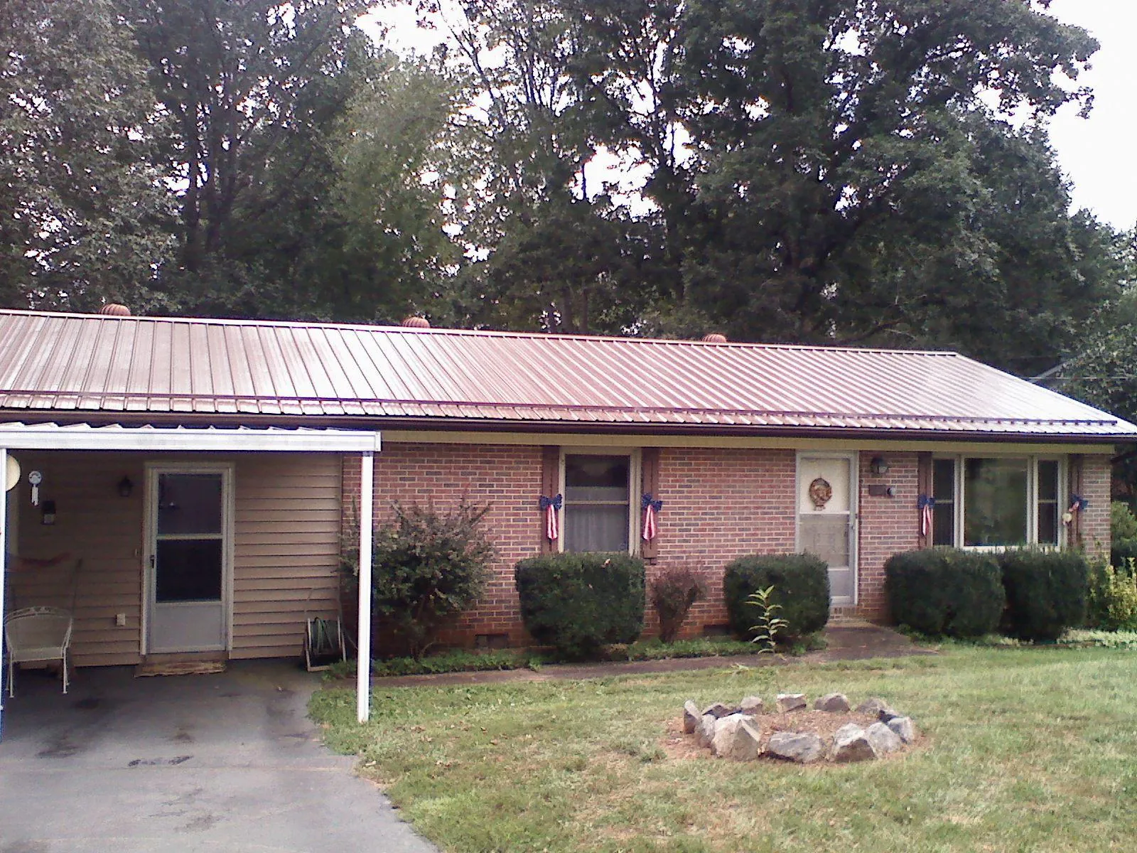 Bronze metal roof and carport on a brick ranch home — Roof Repair work by our crew in Atkins