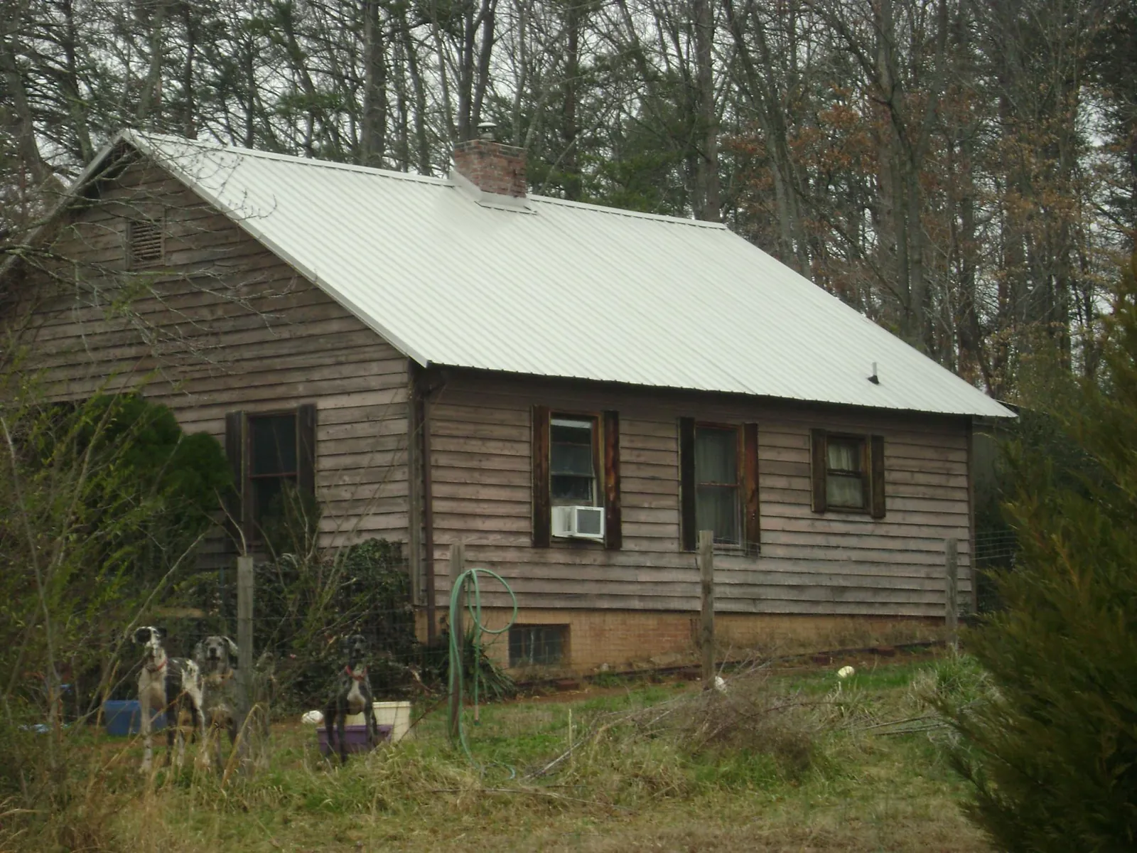 White metal roof on an old wood sided farmhouse, from a Metal Roof Installation job in Atkins